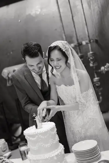 Brautpaar schneidet die Hochzeitstorte an, Schwarz-Weiß